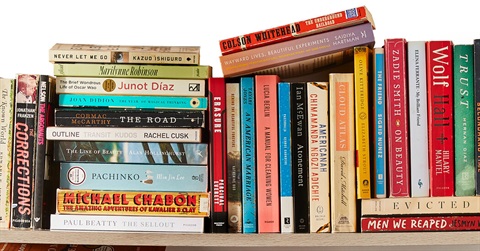A stack of popular paperback books with spines visible